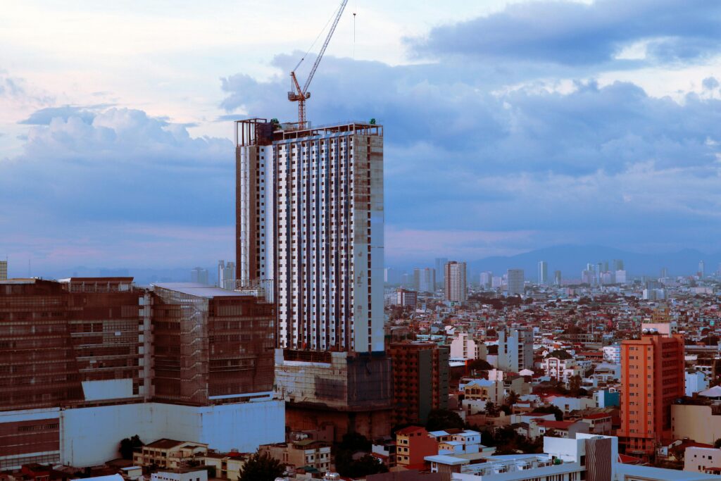 Aerial view of a skyscraper under construction amidst the bustling cityscape of Pasay City, Philippines.